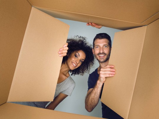 Une femme et un homme regardent dans carton vu dessous