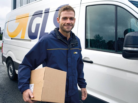 Chauffeur GLS France tient colis côté camion GLS