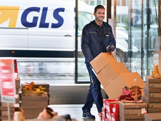 Chauffeur GLS France livre plusieurs colis magasin chaussures camion dehors